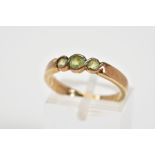A 9CT GOLD THREE STONE RING, set with three circular cut peridots within a cross over mount, to