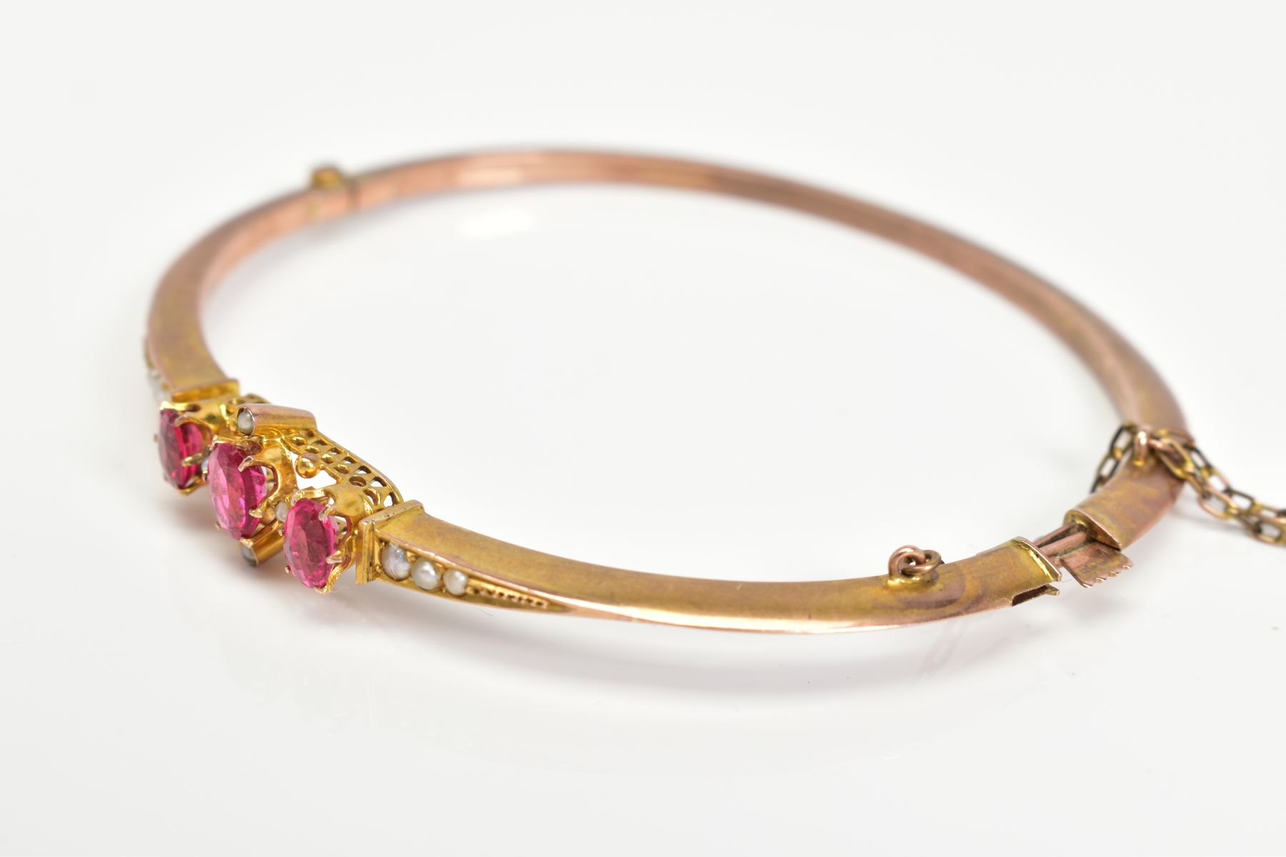 AN EARLY 20TH CENTURY GOLD SPLIT PEARL AND GARNET TOPPED DOUBLET FANCY BANGLE, measuring - Image 2 of 4