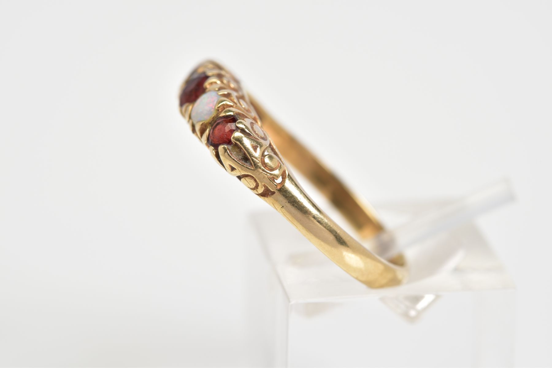 A 9CT GOLD RING, designed as a row of three circular cut garnets interspaced by two circular opals - Image 2 of 3