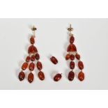 A PAIR OF AMBER MULTI DROP EARRINGS, each designed with post and scroll fittings suspending an
