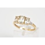 A 9CT GOLD THREE STONE RING, set with three cushion cut colourless stones assessed as goshenite,