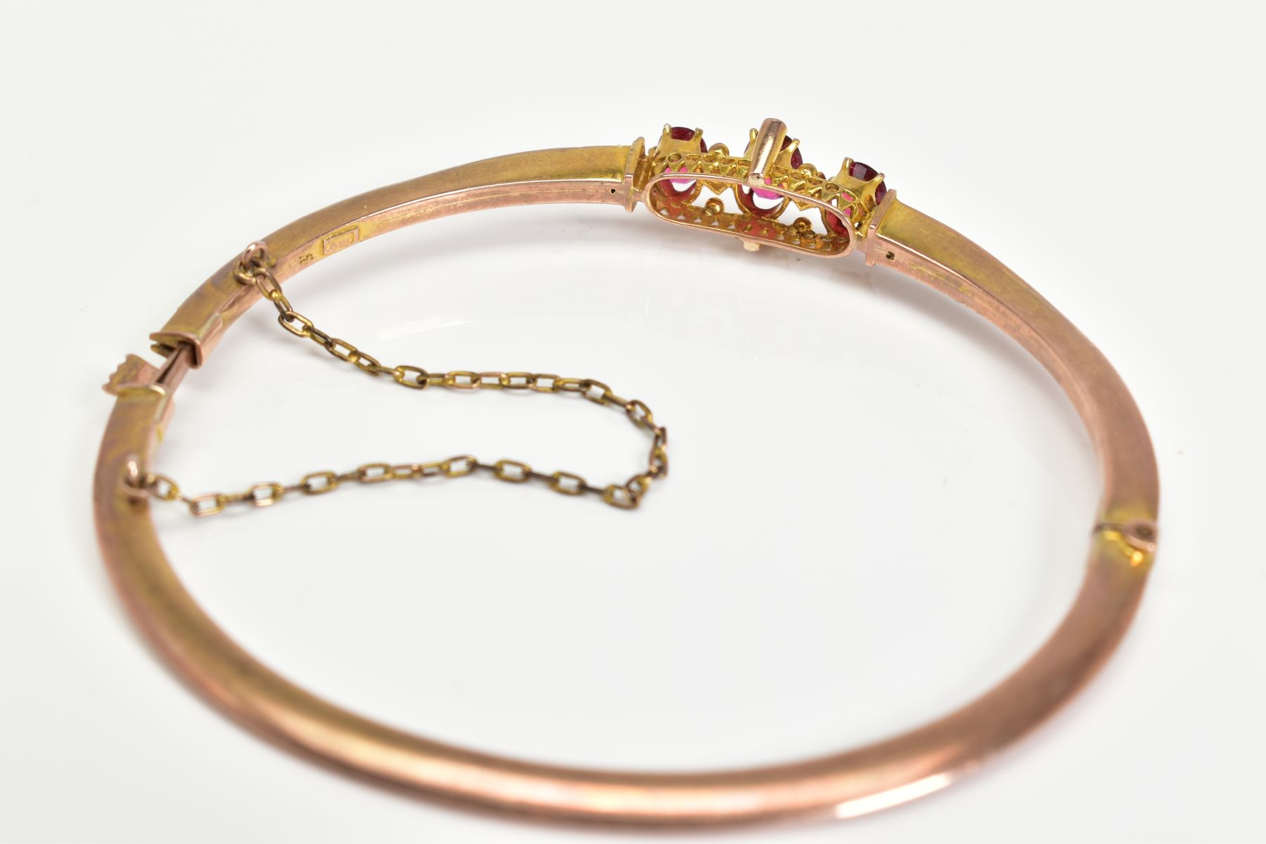 AN EARLY 20TH CENTURY GOLD SPLIT PEARL AND GARNET TOPPED DOUBLET FANCY BANGLE, measuring - Image 4 of 4