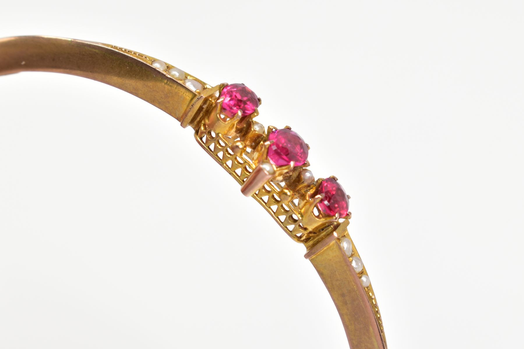 AN EARLY 20TH CENTURY GOLD SPLIT PEARL AND GARNET TOPPED DOUBLET FANCY BANGLE, measuring - Image 3 of 4