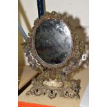 A CAST METAL AND COLD PAINTED OVAL DRESSING TABLE MIRROR, having ivy and berry frame, a shell shaped