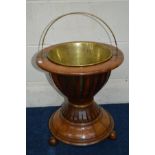 A GEORGIAN WALNUT AND STRUNG JARDINIERE STAND, brass handle and removable liner, of a spindled