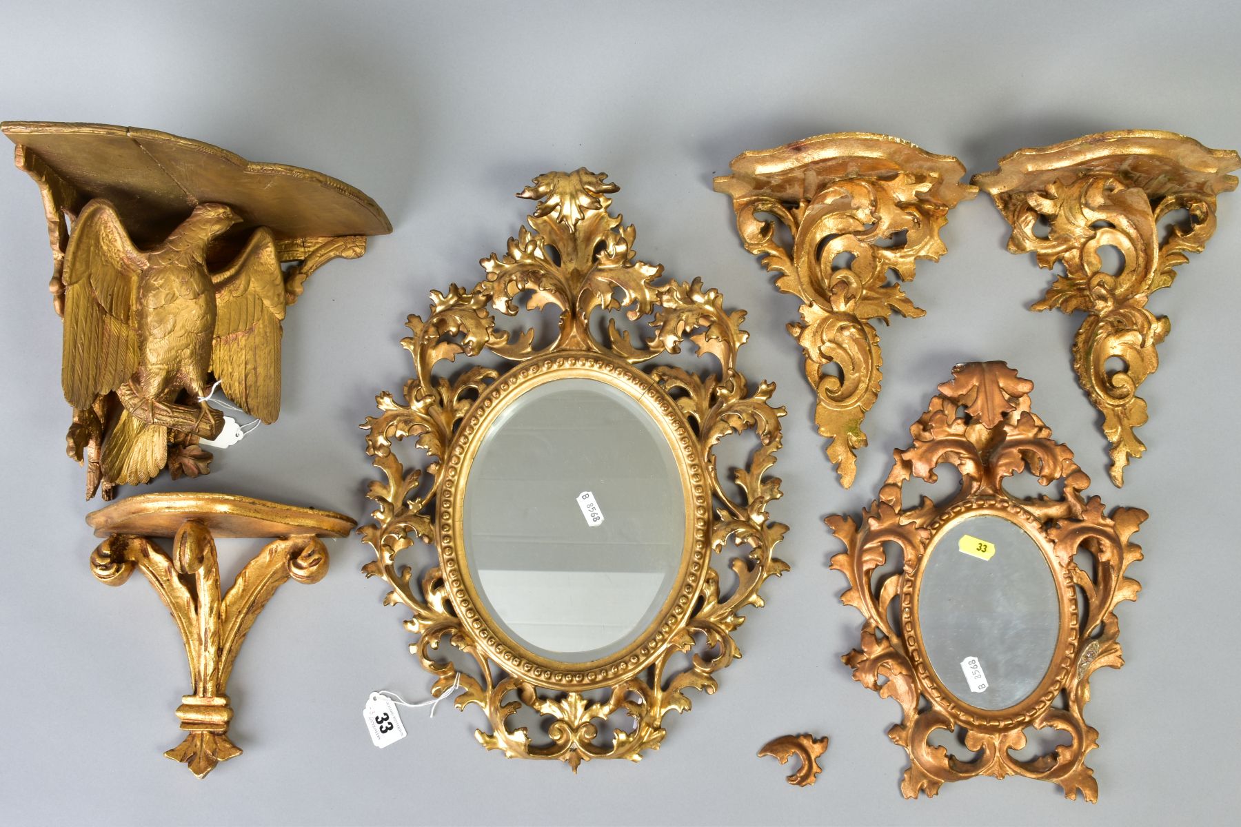 A COLLECTION OF SIX GILTWOOD ITEMS, comprising two small oval mirrors within ornate foliate