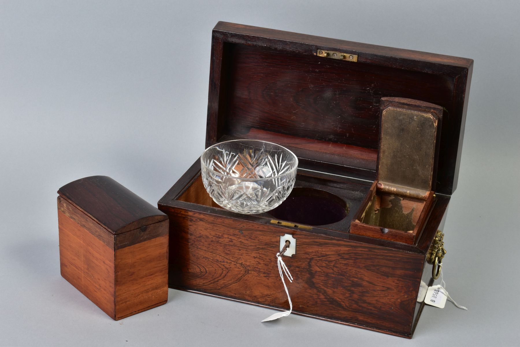 AN EARLY VICTORIAN ROSEWOOD TEA CADDY, of sarcophagus form, gilt metal lion mask and ring side