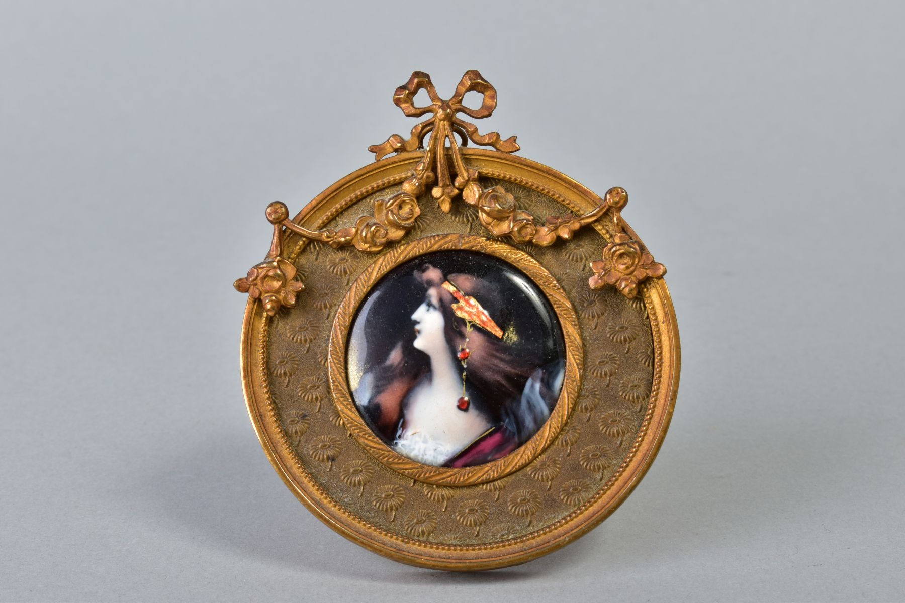 AN EARLY 20TH CENTURY FRENCH LIMOGES STYLE ENAMEL PORTRAIT PLAQUE OF A LADY, with ornate head dress,