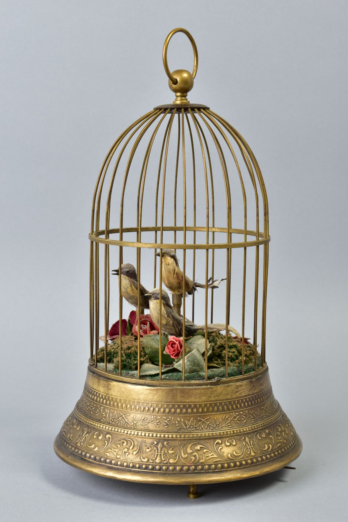 AN EARLY 20TH CENTURY CLOCKWORK AUTOMATON OF A CAGE OF THREE BIRDS, stamped brass base, on three