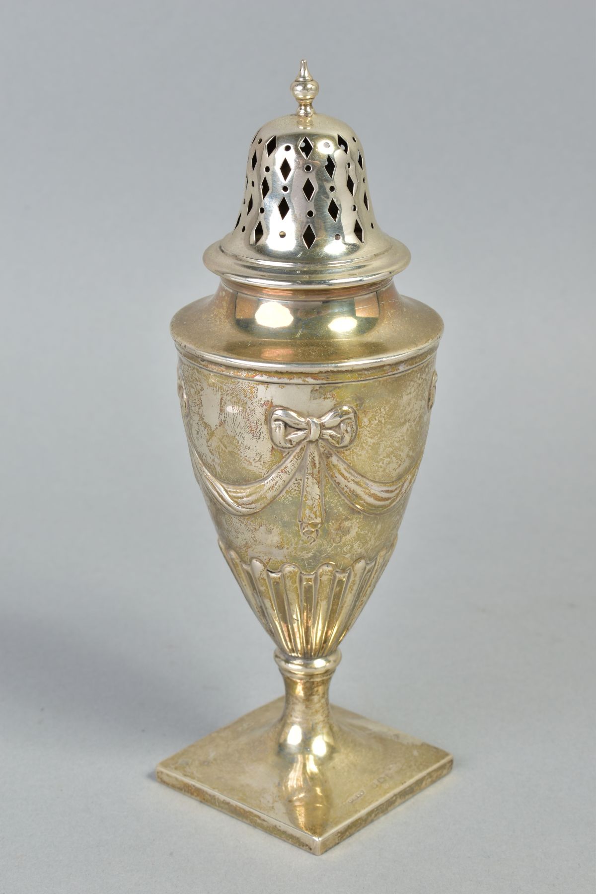 AN EDWARDIAN SILVER CASTER OF URN FORM, pierced domed cover with knopped finial, the base embossed