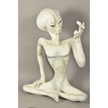 A NOVELTY FIGURE OF A SEATED ALIEN, holding a hand rolled cigarette, height 67cm