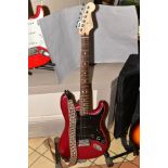 A MEXICAN FENDER STRATOCASTER ELECTRIC GUITAR with metallic red finish, black scratchplate and