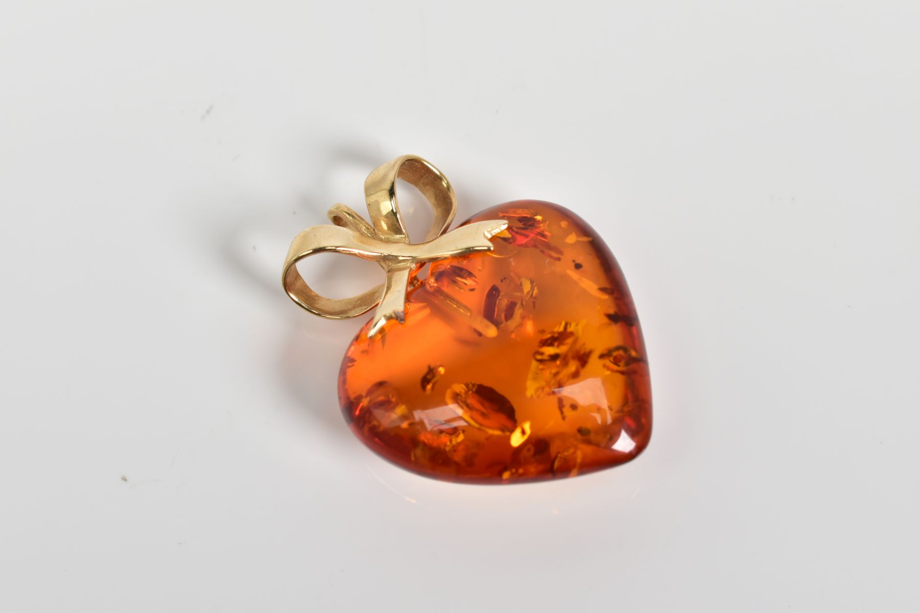 A MODERN 14CT GOLD AMBER HEART PENDANT, measuring approximately 23mm in diameter, fancy bow - Image 2 of 3