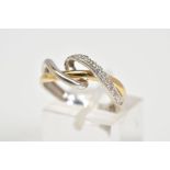 A DIAMOND SET CROSSOVER RING, of white and yellow metal open work crossover style, set with a