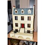 AN IMPRESSIVE WOODEN DOLLS HOUSE, modelled as a three storey town house with a basement, top three