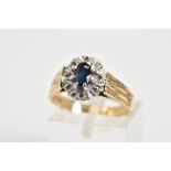 A 9CT GOLD CLUSTER RING, designed with a central; oval cut sapphire within an eight claw setting and