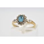 A 9CT GOLD CLUSTER RING, designed with a central oval cut blue topaz and single cut diamond surround