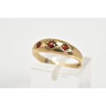 A 9CT GOLD THREE STONE RING, set with three graduated circular cut garnets within a plain polished