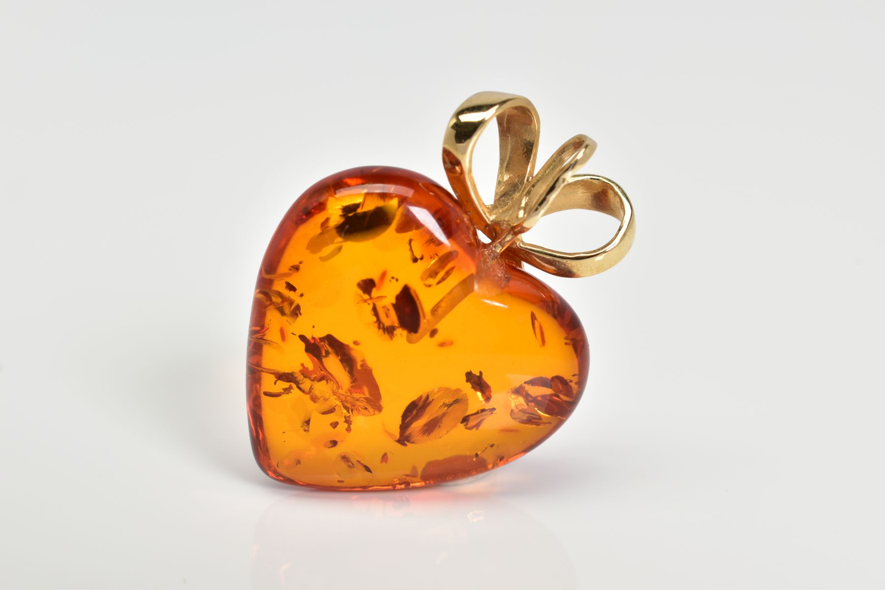 A MODERN 14CT GOLD AMBER HEART PENDANT, measuring approximately 23mm in diameter, fancy bow - Image 3 of 3