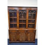 A REPRODUX MAHOGANY GLAZED TRIPLE DOOR BOOKCASE, with three drawers above three cupboard doors,