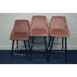 A PAIR OF PINK VELVET BAR STOOLS, on tapering tubular frame united by a brassed footrest, together