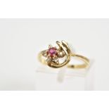 A 9CT GOLD CLUSTER RING, designed as a flower with a central circular cut ruby and brilliant cut