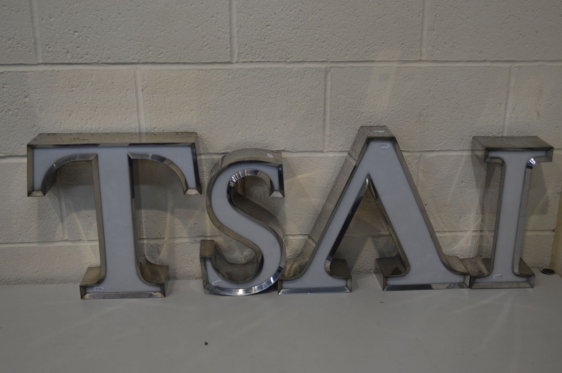 FOUR STAINLESS STEEL ADVERTISING LETTERS, include the letters T, S, A, I