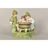 A LARGE BISQUE FIGURE GROUP, depicting children gathered around a wash tub, painted details,