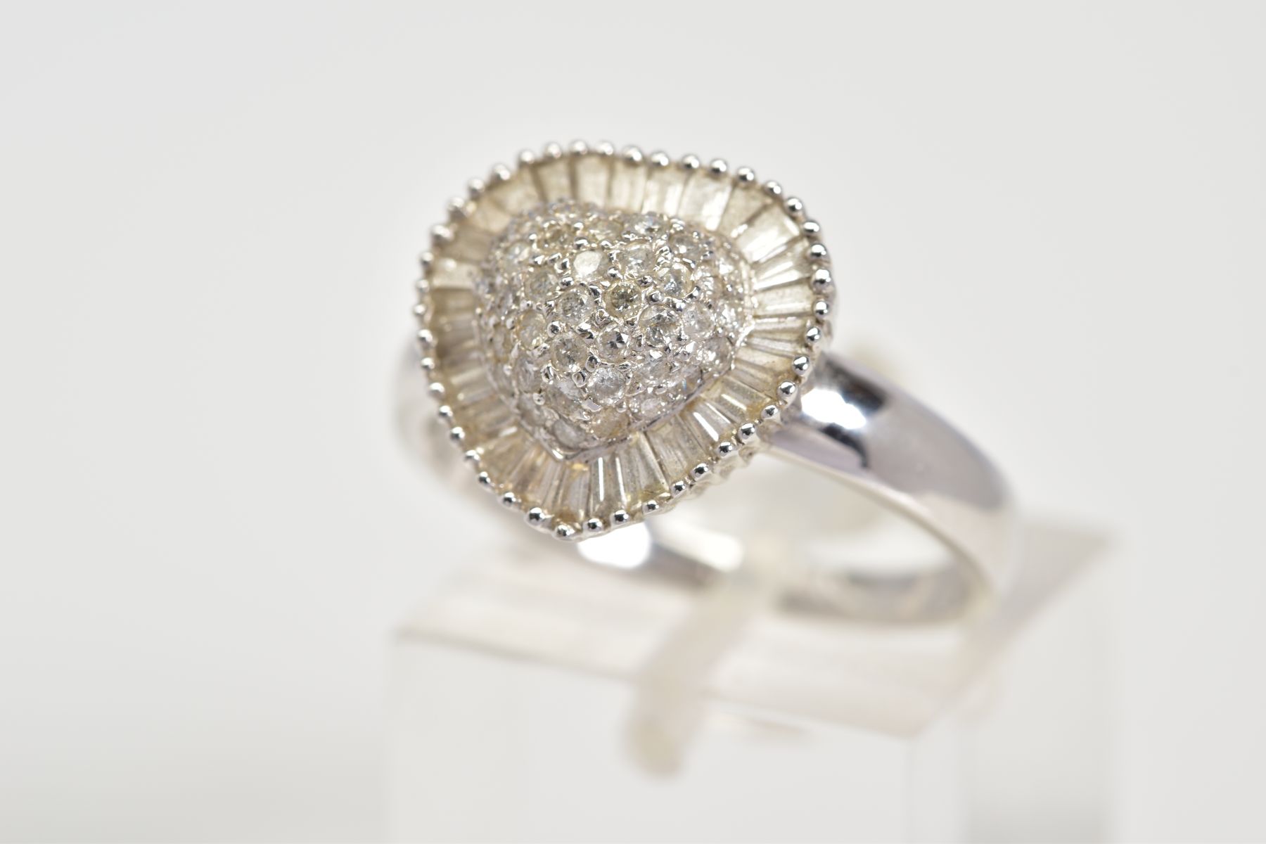 A DIAMOND RING, of heart shape design, the central raised panel set with round brilliant cut