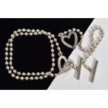 A SILVER GUCCI NECKLACE AND BRACELET, the necklace of a heart toggle design engraved with Gucci,