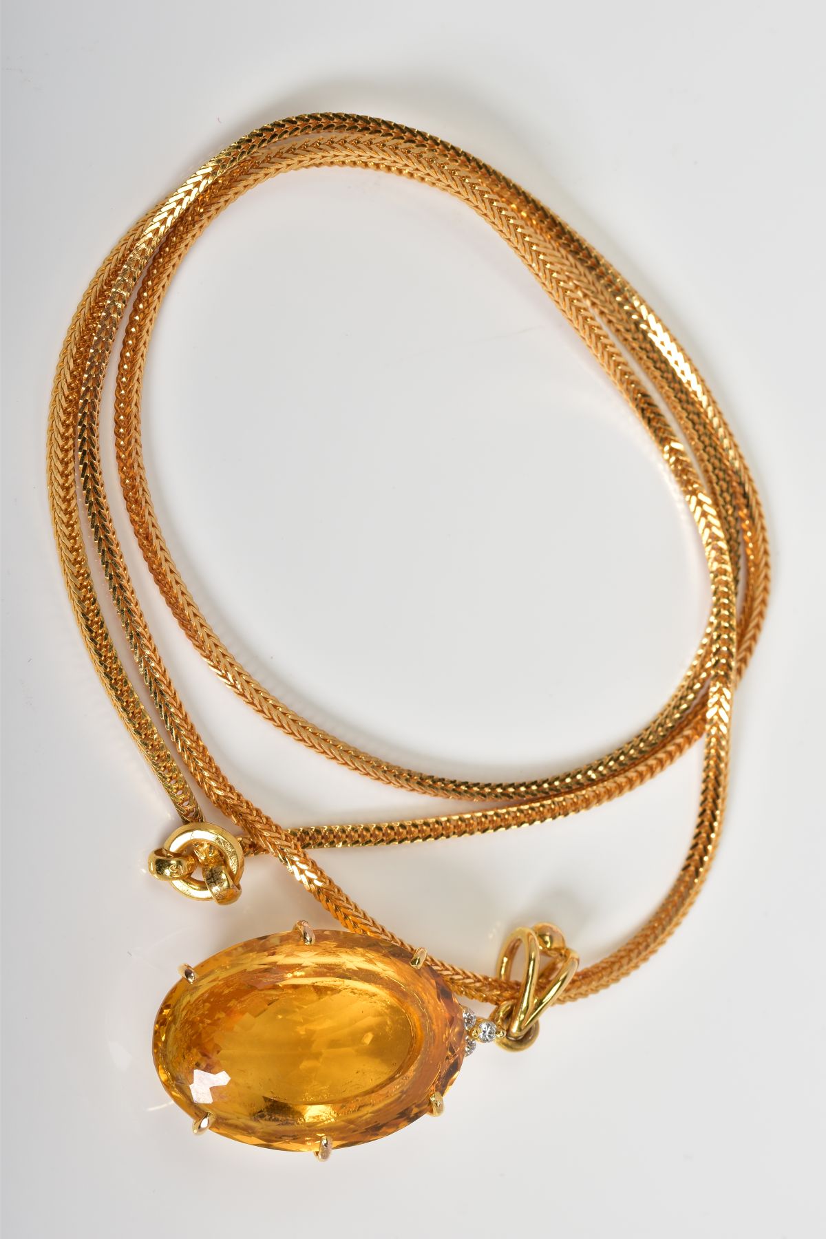 A LARGE CITRINE AND DIAMOND PENDANT AND CHAIN, oval mixed cut citrine stone measuring