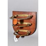 A NOVELTY LETTER RACK, equestrian interest being three brass graduated stirrups, on leather