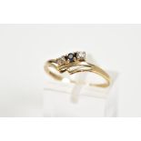 A 9CT GOLD RING, designed with a double V shape shank with a row of two round brilliant cut cubic
