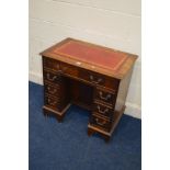 A MODERN MAHOGANY KNEE HOLE DESK, with a red gilt tooled leather inlay top, above nine assorted