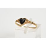 A 9CT GOLD RING, designed with a central onyx heart and scrolling detail shoulders, with a 9ct