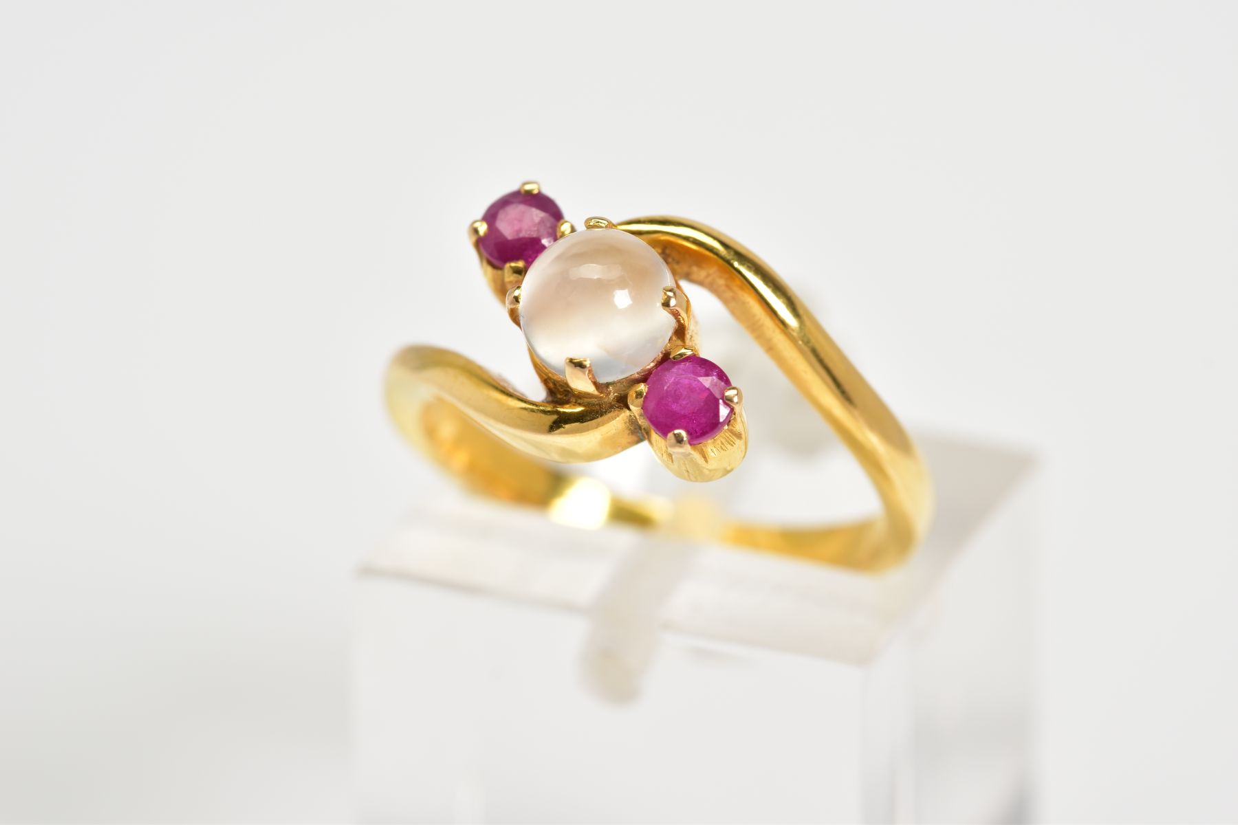 A MODERN RUBY AND MOONSTONE THREE STONE CROSS OVER DRESS RING, ring size J, approximate gross weight