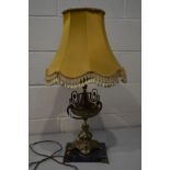 A BRASS EWER SHAPED TABLE LAMP on a slate base with a fabric shade (one loose foot)