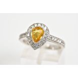 A YELLOW TOPAZ SET RING, the white metal ring set with a pear cut topaz with a round brilliant cut