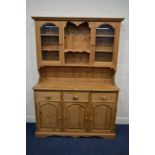 A MODERN PINE KITCHEN DRESSER, the top with double glazed doors above a base with three drawers,