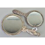 TWO SILVER MOUNTED HAND HELD MIRRORS, both with floral and foliate design, the first with an