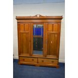 AN EDWARDIAN WALNUT TRIPLE DOOR COMPACTUM WARDROBE, with a central mirrored door, the left section