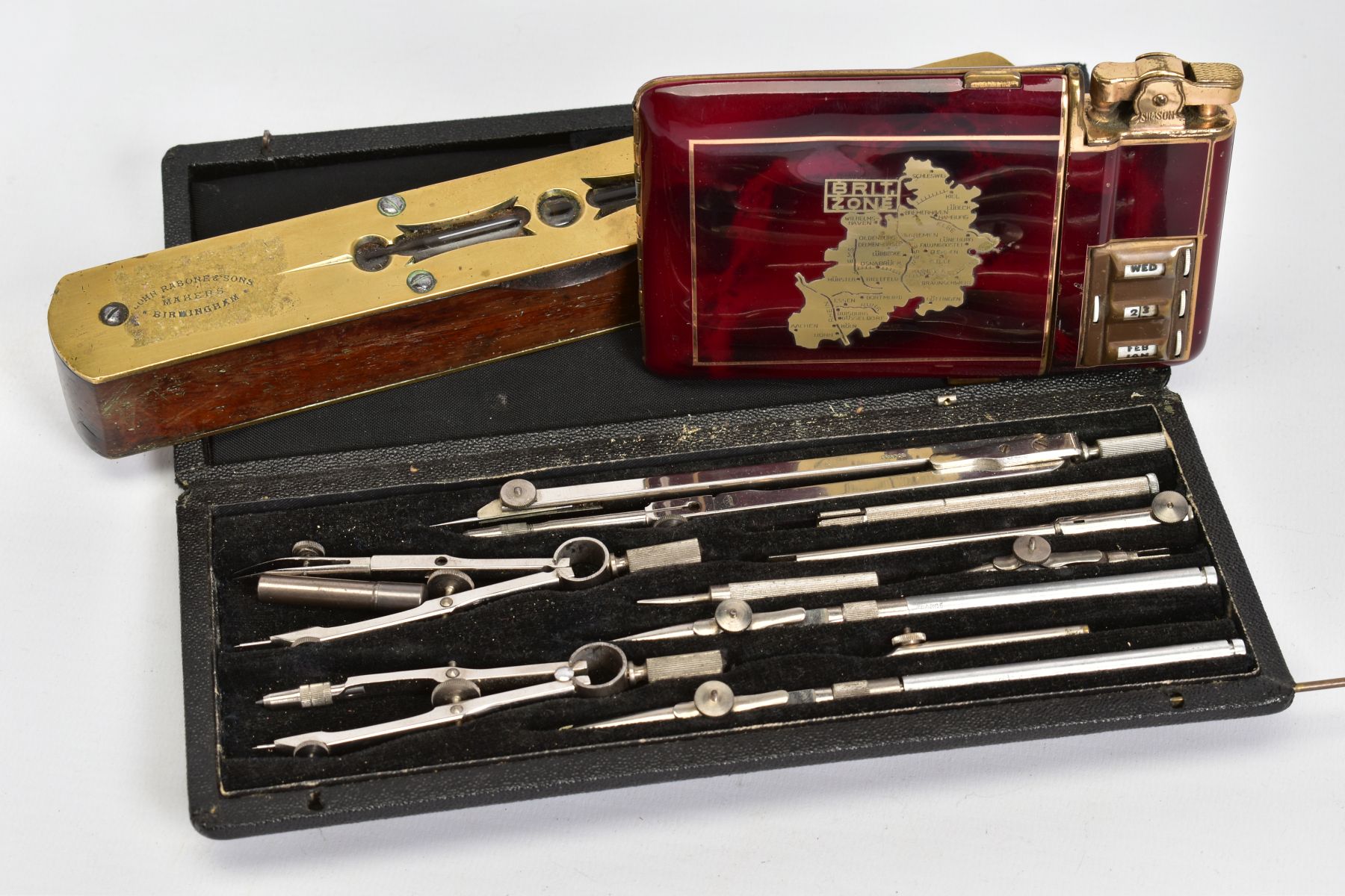 A SELECTION OF ITEMS, to include a red enamel cigarette case with attached lighter and calendar to