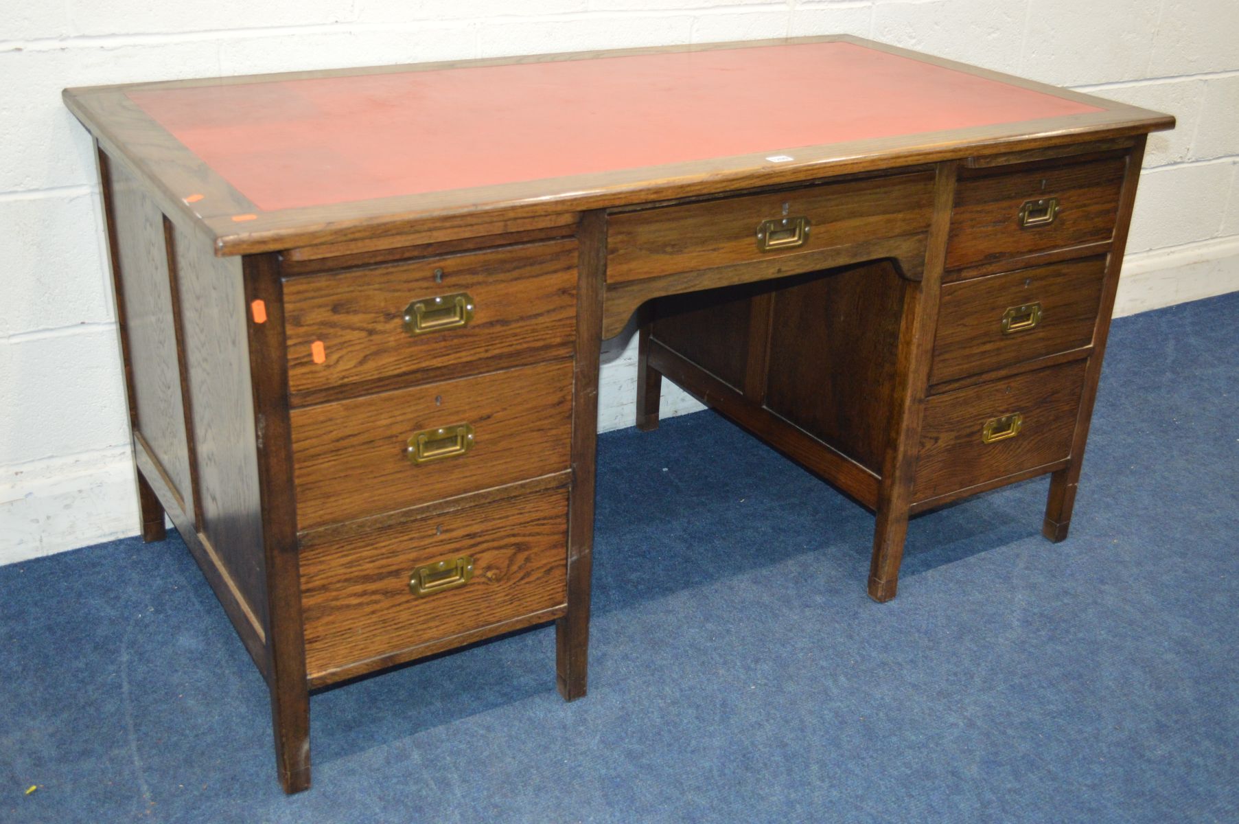 A MID 20TH CENTURY STAINED OAK KNEE HOLE DESK, with a red leather top and seven drawers with brass - Image 2 of 3