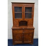 A HARDWOOD GLAZED TWO DOOR CABINET with eight various drawers above double panelled cupboard