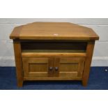 A SOLID GOLDEN OAK CORNER TV STAND with double cupboard doors, width 85cm x depth 45cm x height