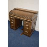 AN EARLY TO MID 20TH CENTURY OAK ROLL TOP DESK, with a fitted interior and eight assorted drawers,