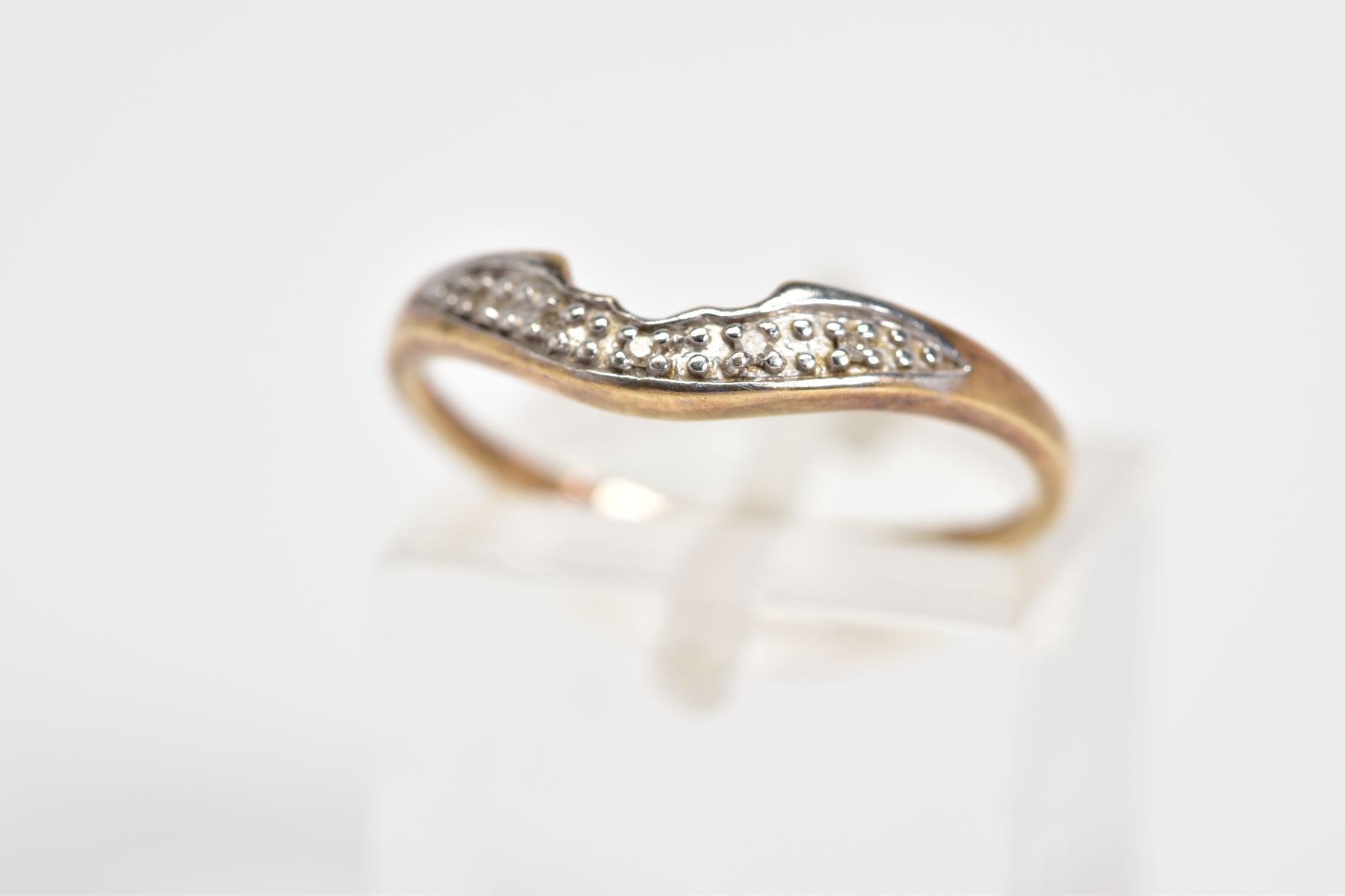 A 9CT GOLD DIAMOND RING, of V shape design, set with a row of single cut diamonds, to the plain