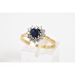 AN 18CT GOLD CLUSTER RING, set with a central heart shape sapphire with a round brilliant cut