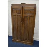 AN EARLY TO MID 20TH CENTURY OAK LINENFOLD TWO DOOR GENTLEMANS WARDROBE, with a hinged secret door