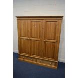 A MODERN PINE TRIPLE DOOR WARDROBE, with two drawers, width 176cm x depth 62cm x height 191cm